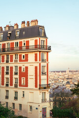 : A classic Parisian apartment building with a distinct red and white facade in Montmartre.