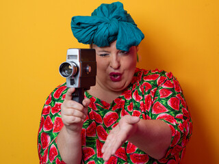 Retro plus size woman filming with vintage camera