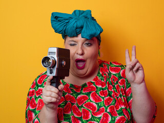 Retro plus size woman filming with vintage camera