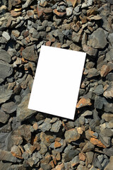 Mockup of white A4 sheet on stones of mountain rivers. Layout of poster on stone background. Poster mockup, blank with space for text, presentation template