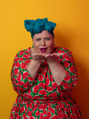 Plus size woman smiling and touching head in watermelon dress