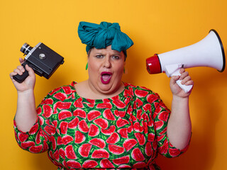 Plus size woman shouting with megaphone and holding vintage camera
