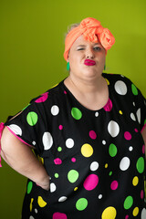Plus size woman in vibrant polka dot outfit making a comic shrug gesture with outstretched hands and amusing expression.