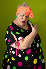 Plus size woman in vibrant polka dot outfit making a comic shrug gesture with outstretched hands and amusing expression.