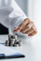 Business person holding and stacking coins on the table, future investment, retirement