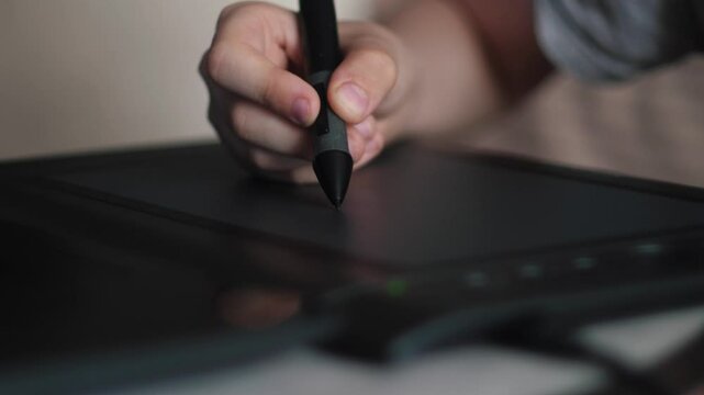 drawing on professional graphic tablet close-up, child's hand drawing with stylus on graphic tablet, batch processing and drawing on gadget