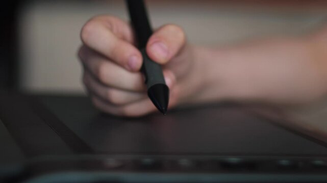 drawing on professional graphic tablet close-up, child's hand drawing with stylus on graphic tablet, batch processing and drawing on gadget