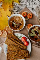 Cozy autumn vibes with herbal tea, homemade bread, dried citrus slices, and seasonal decor – a perfect setting for relaxation and warmth.