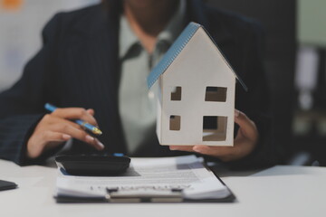 Real estate agents explain models of housing estates in projects to elaborate to clients, explaining and presenting information about homes and purchasing loans. Real estate trading concept.