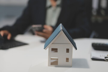 Real estate agents explain models of housing estates in projects to elaborate to clients, explaining and presenting information about homes and purchasing loans. Real estate trading concept.