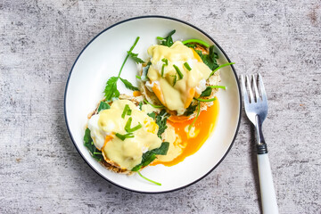 top view of eggs benedict with spinach on a plate as a breakfast menu