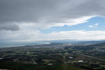 Fototapeta premium A series of analog-style landscape photographs captured through a car window during a road trip in South Africa. The images show vast rural scenery, dramatic skies, mountain silhouettes, townships, an