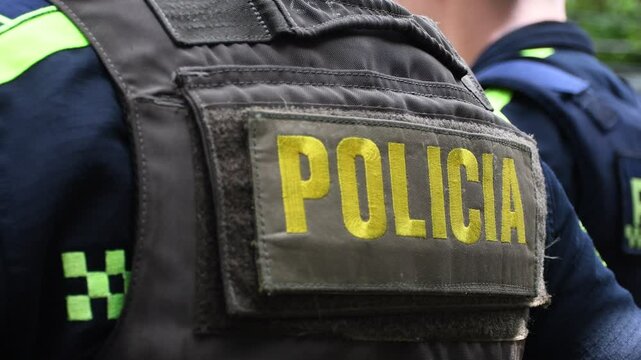 Close-up "POLICE" marking written on the back of a bulletproof vest worn by a Colombia police officer. Concepts of security, crime and police cases in Colombia