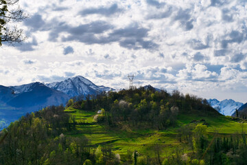 Mountain range with a cloudy sky and a small house in the middle