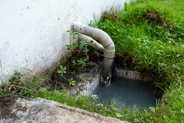 Pipe is leaking water into a grassy area