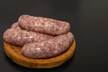 Meat sausages prepared for grill on a wooden board. Raw sausages for grill.