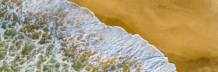 Florianópolis, Campeche beach during sunrise. Brazil. Rio Tavares neighborhood. Wave formation in web banner aerial view.