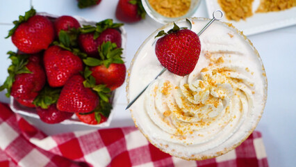 Making Strawberry Shortcake Martinis for a Spring party in the garden.  Using red gingham napkins to place our fruity dessert martinis on.  Close up of strawberries in the summertime. Cocktails 