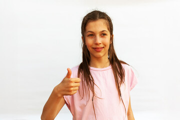 I like it. Portrait of joyful teenage girl showing thumbs up and smiling at camera, white background with copy space