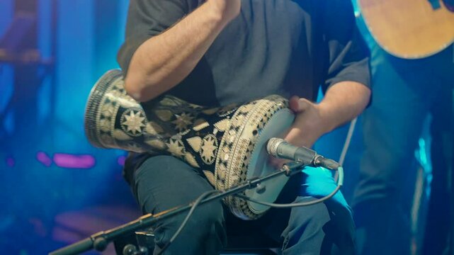 A man on stage plays the darbuka. High quality FullHD footage