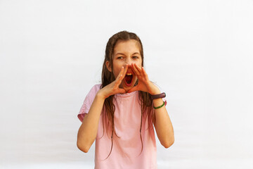 Teen girl screaming like a megaphone holding hands to face with mouth open. Young woman advertising to everyone on white background.