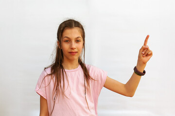 Happy teenage girl pointing finger to the side on white background