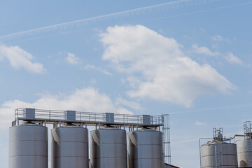 Silver Storage Tanks under Cloudy Blue Sky