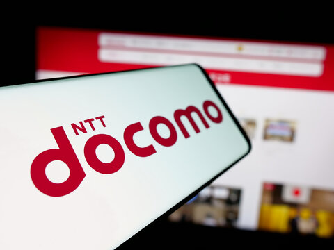 Stuttgart, Germany - 05-31-2025: Smartphone with logo of telecommunications company NTT Docomo Inc. on screen in front of website. Focus on left of phone display.