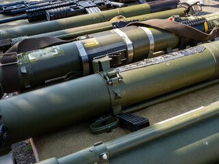 A group of military weapons are lined up, including a rifle