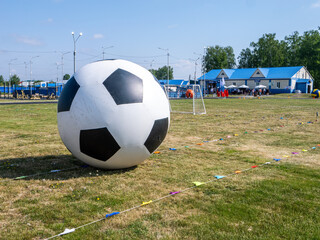 A large inflatable soccer ball sits on a field