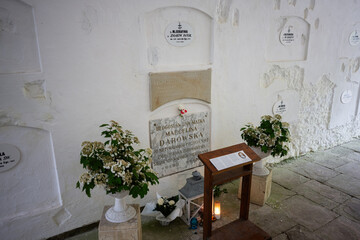 Memorial site for Marcelina Darowska nun with floral tributes and candles indoors