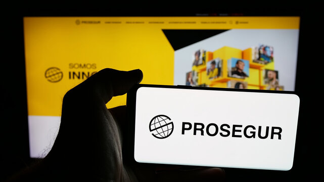 Stuttgart, Germany - 05-31-2025: Person holding mobile phone with logo of company Prosegur Compania de Seguridad S.A. on screen in front of web page. Focus on phone display.