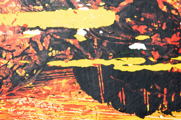 Thick red black and yellow paint in a scribbled abstract background