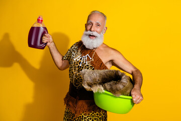 Portrait of primeval caveman hodl laundry wash gel bottle leopard skin animal fur outfit isolated on yellow color background