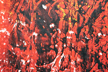 Thick red black and yellow paint in a scribbled abstract background