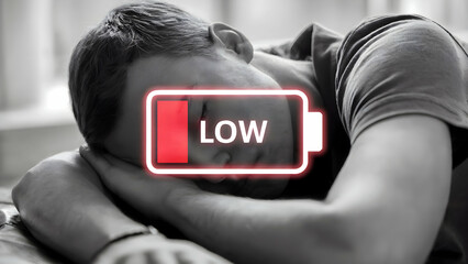 Exhausted young man sleeping soundly low energy levels displayed as a battery indicator showcasing fatigue sleep deprivation and tiredness needing rest and relaxation