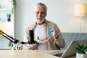 Radio host showing blue ribbon during podcast recording discussing men's health issues