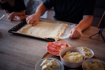 Preparing Homemade Pizza with Fresh Ingredients on Table