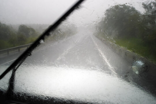 Heavy rain and American truck driving on highway. View from inside the car, car wipers cleaning the windshield - Powered by Adobe