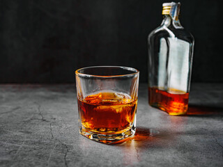 Strong alcohol drink and whiskey bottle Whisky in glass with ice, Whisky, bourbon or cognac. Hard strong alcoholic drink