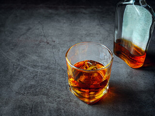 Strong alcohol drink and whiskey bottle Whisky in glass with ice, Whisky, bourbon or cognac. Hard...
