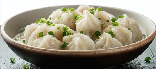 dumplings in a bowl sprinkled with green onions