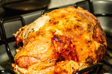    Roasted turkey breast, in a roasting pan resting, before it is sliced