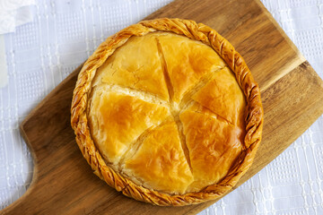 Delicious cooked cheese pie showing delicious cheese pie and crust on a wooden board.