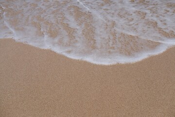 Waves breaking on the sand. Ocean wave, golden sand, white sea bubble foam, Coast tropical summer vacation