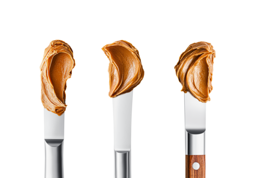 Peanut butter smear on tip of knife, close up. Set of steel cutlery with swirled food texture. Realistic photo for packaging design. Isolated clipart with clear even edge on transparent background