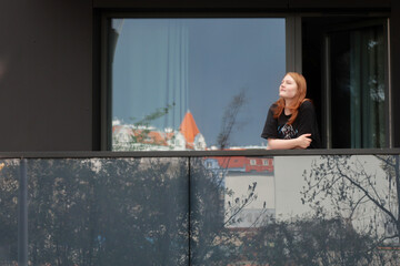 teenager girl standing on balcony in european city