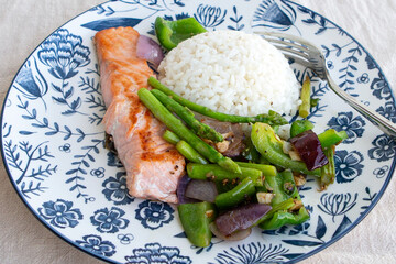 plate of fried salmon with rice and asparagus on the table