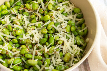 pan of edamame beans with parmesan and garlic close up
