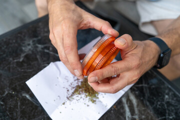 Middle-Aged Man Grinding Cannabis for Recreational and Medical Use